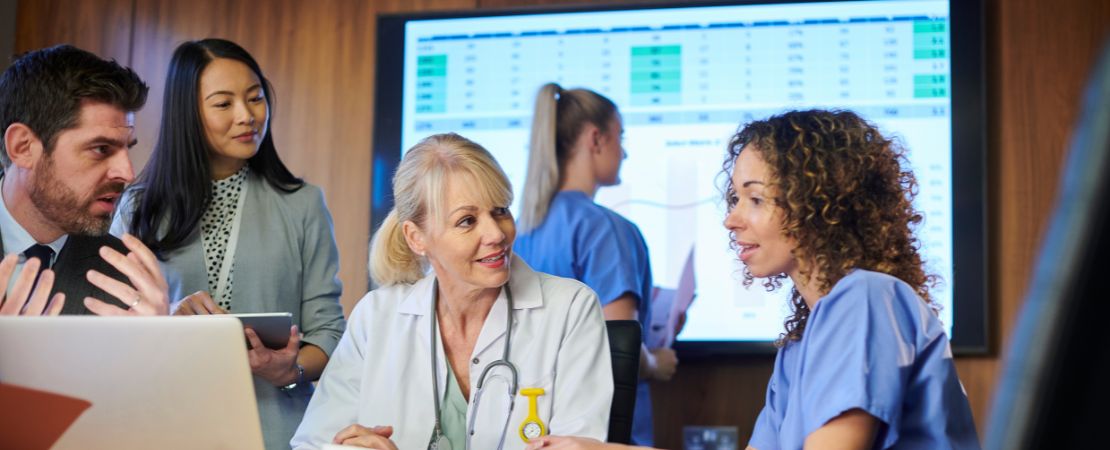 A group of medical professionals in a meeting room collaborating